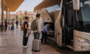 Modern intercity coach at a Moroccan bus station with travelers preparing to board