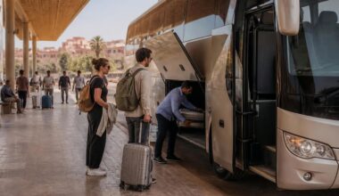 Modern intercity coach at a Moroccan bus station with travelers preparing to board